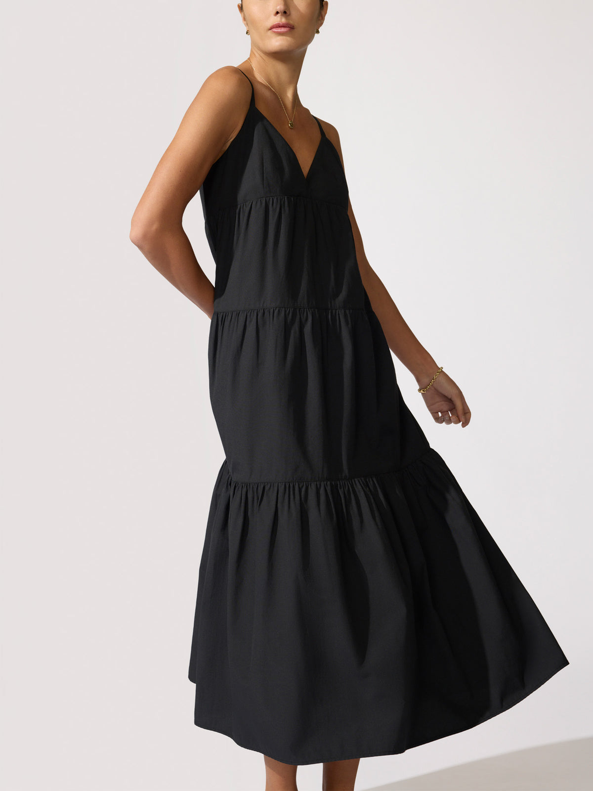 Woman wearing a black tiered midi dress with thin straps