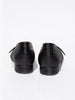 Black crocodile-embossed leather flats shown from the back, with a low block heel