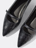 Black crocodile-embossed leather pumps with pointed toe and mary-jane strap, close-up top-down shot