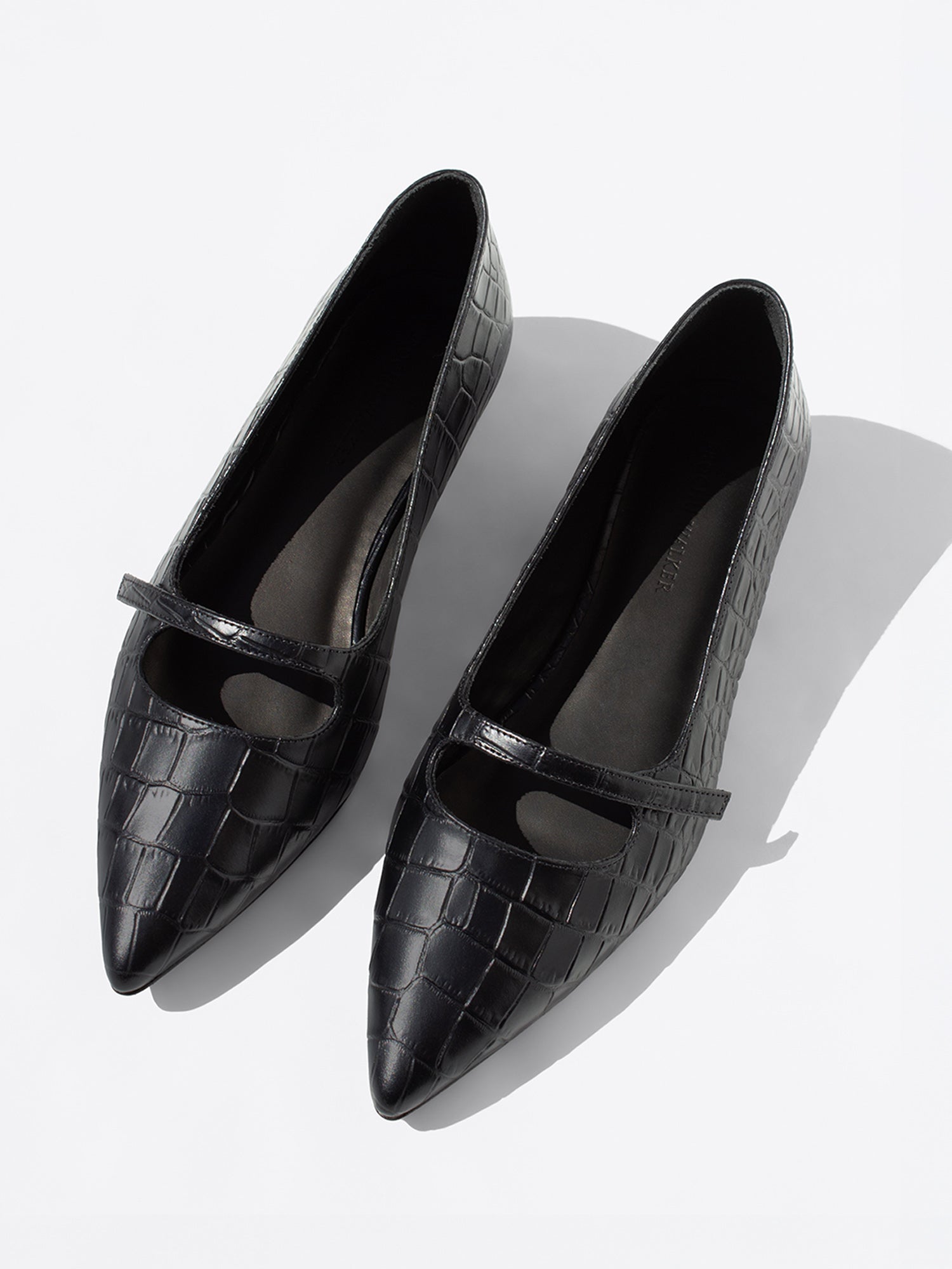 Black crocodile-embossed leather flats with pointed toe and mary-jane strap, pair shown together