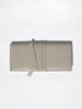 Light taupe crocodile-embossed leather clutch wallet with wrap-around strap closure, flat product shot