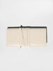 Ivory croc-embossed leather clutch bag lying flat, showing its wrap tie and black top trim