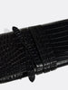 Close-up of the wraparound tie strap detail on a black crocodile leather clutch bag