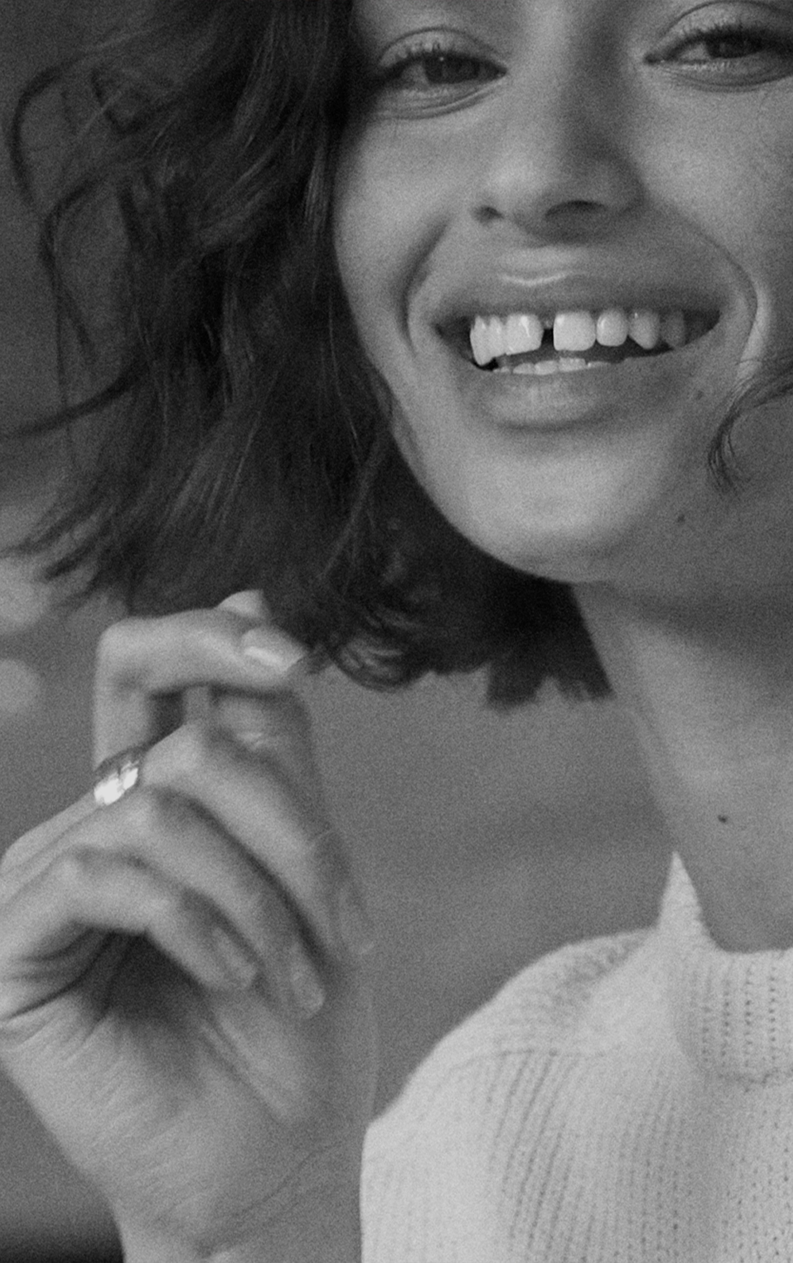 model with short hair wearing a white brochu knitwear and looking int the camera