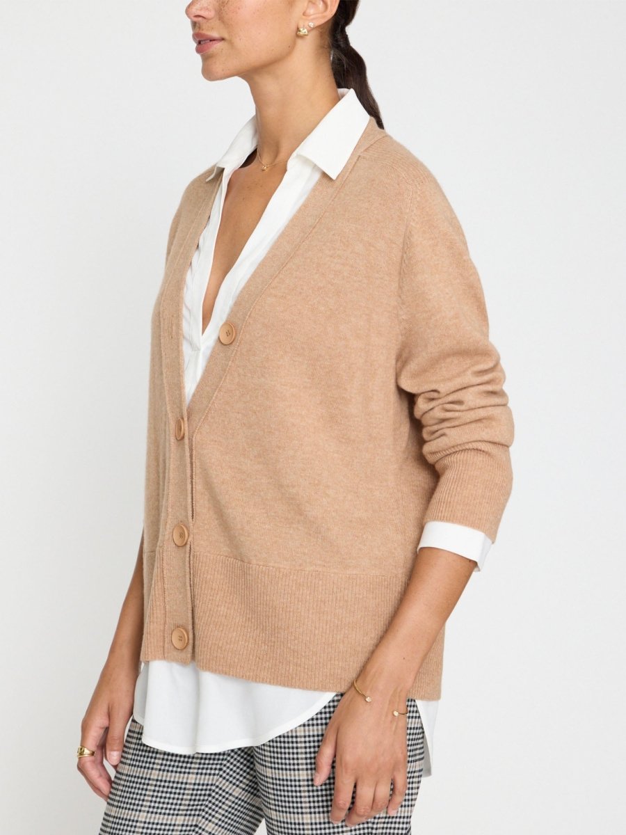 Luxury cardigan for women in camel with button front, layered over a white shirt and styled with plaid trousers.