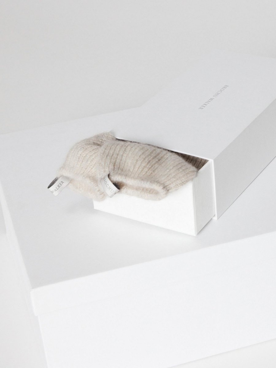 Ribbed cashmere socks in mist mélange folded on a white Brochu Walker gift box.