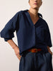 Kate shirt in navy with voluminous puff sleeves, tucked into indigo jeans with a tan leather belt