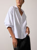 Woman modeling a women's white button-up shirt with puffed elbow sleeves and a black skirt