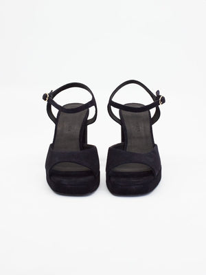 Women's black high heels with open toes, ankle straps, and chunky platform soles for added height and comfort.