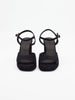 Women's black high heels with open toes, ankle straps, and chunky platform soles for added height and comfort.