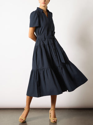 Women's navy dress with short sleeves, a belted waist, and tiered midi skirt paired with beige block-heel sandals.
