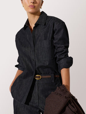 Denim shirt for women styled with matching dark wash jeans and a slim brown belt for a monochrome look.
