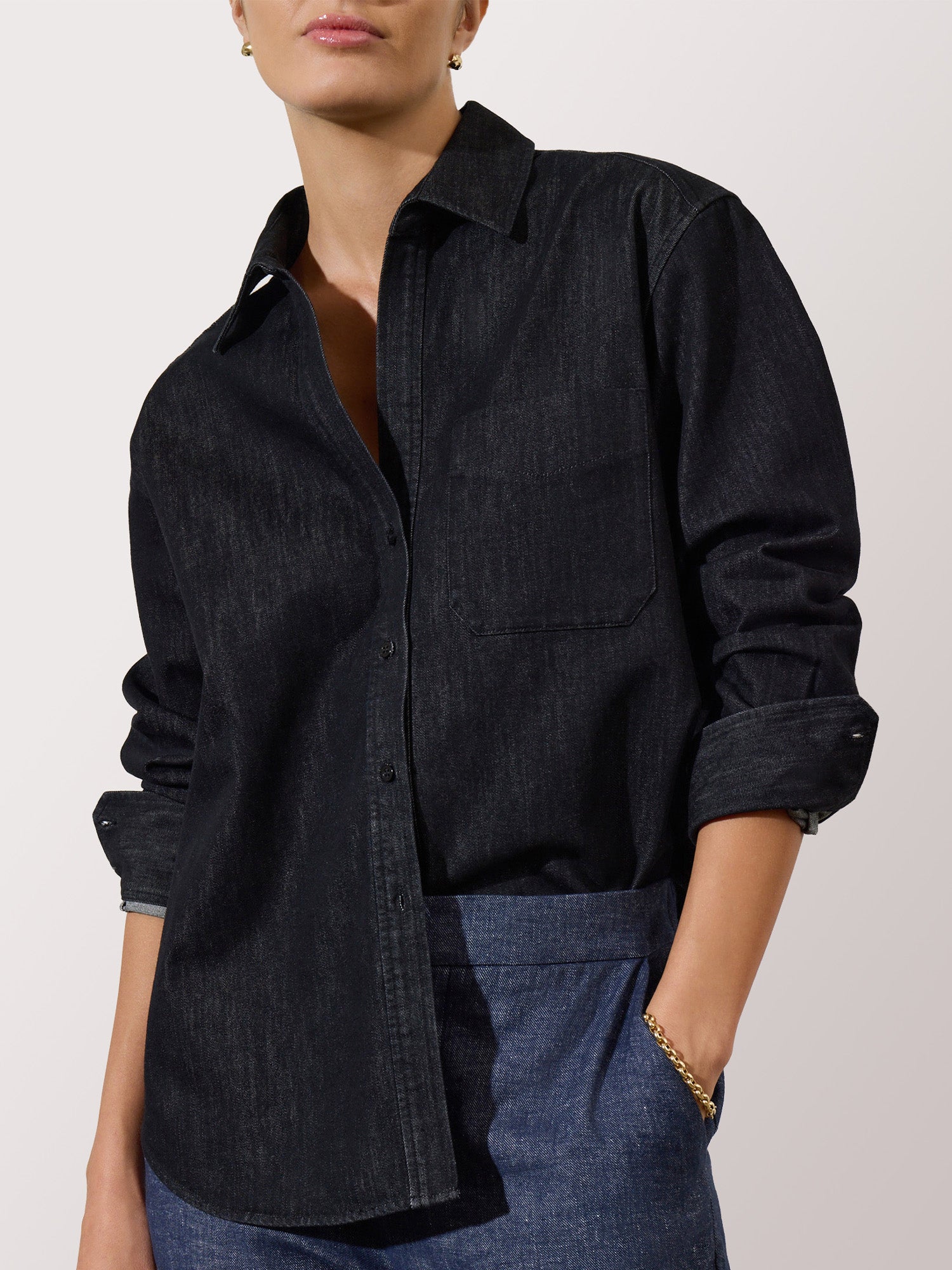 Denim shirt for women styled with blue denim jeans and a gold link bracelet.