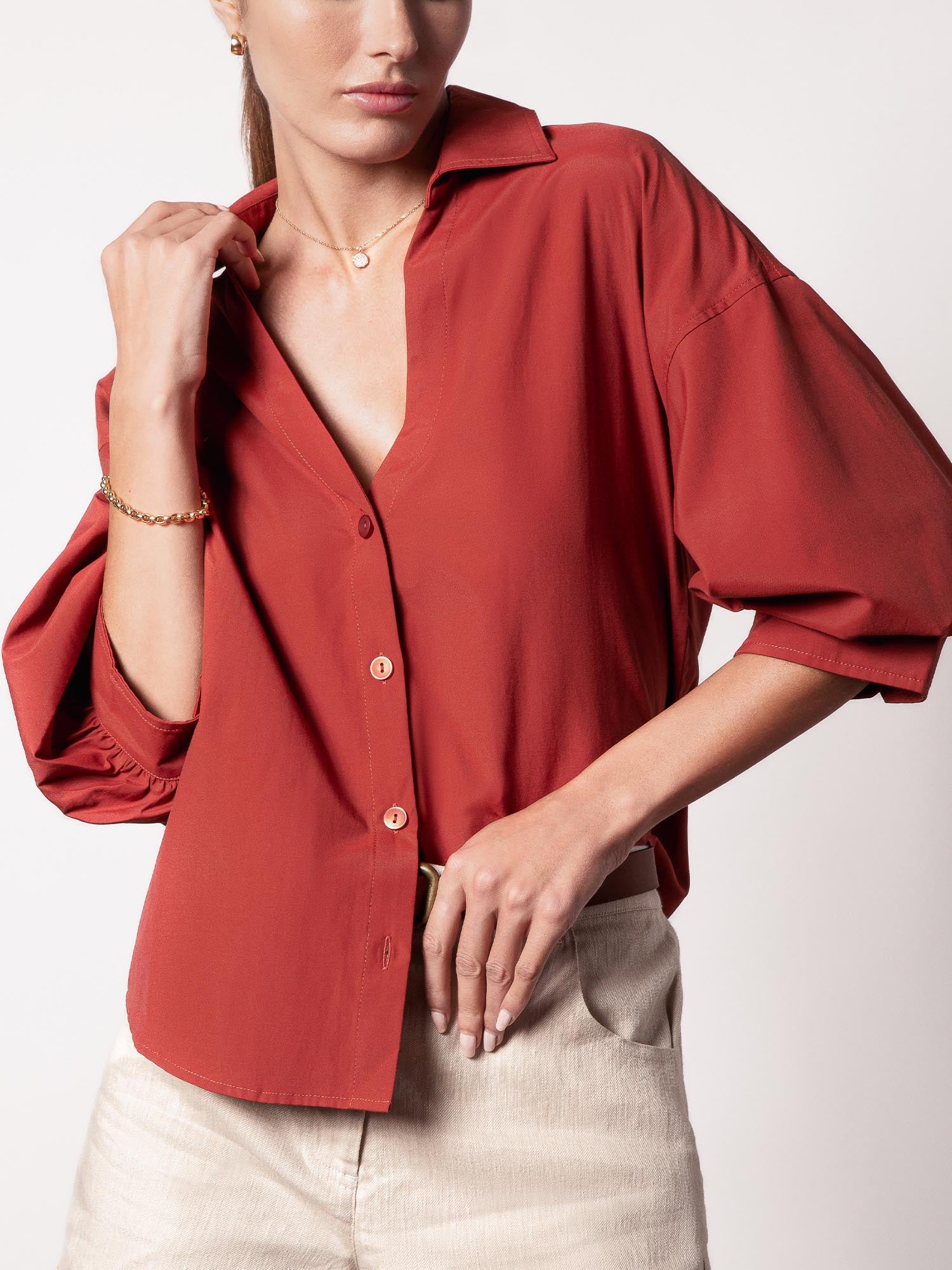 Button-up shirt in tuscany rust with voluminous puff sleeves, styled with beige bottoms