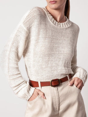 White knit pullover for women featuring a relaxed fit, ribbed neckline, and lightweight texture styled with high-waisted shorts.