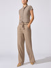 Woman wearing the Emmy cardigan in otter melange with a tie waist, paired with taupe wide-leg trousers