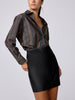 Woman wearing the Everyday shirt in Sedona stripe, tucked into a black faux-leather mini skirt