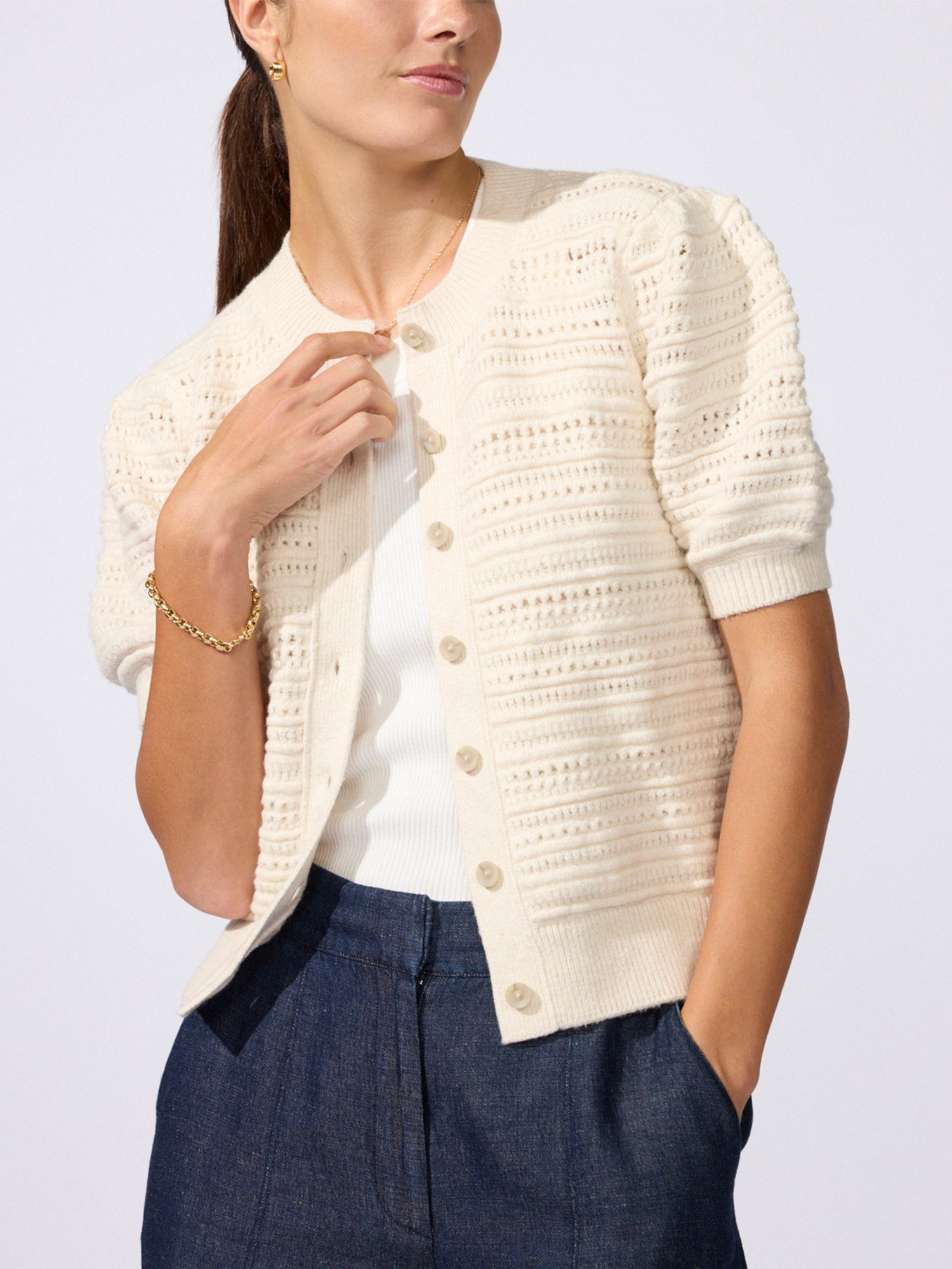 Havana multi-stitch cardigan in oatmeal melange, model wearing textured knit cardigan over a white top with navy trousers