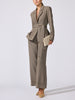 Full-length view of the Lincoln blazer in gravel melange, belted, with matching wide-leg trousers and a beige clutch