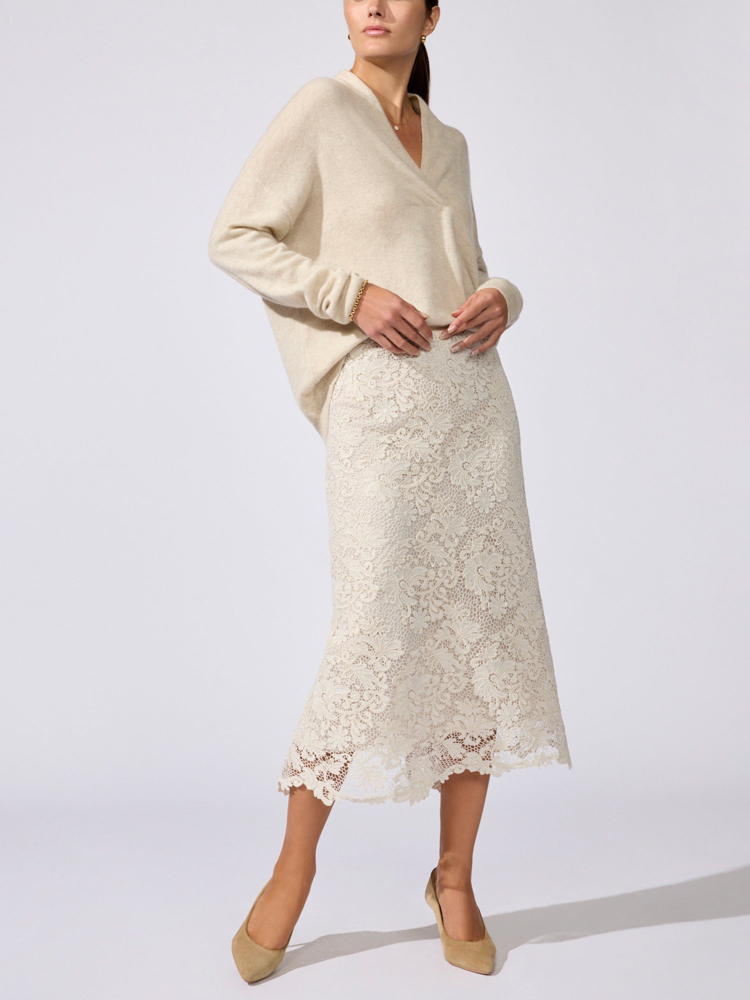 Siena wrap-neck cashmere pullover in stone melange worn with a cream lace midi skirt