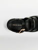 Black strappy sandals with a padded footbed, gold buckle ankle strap, and Brochu Walker branding shown from a top-down view.