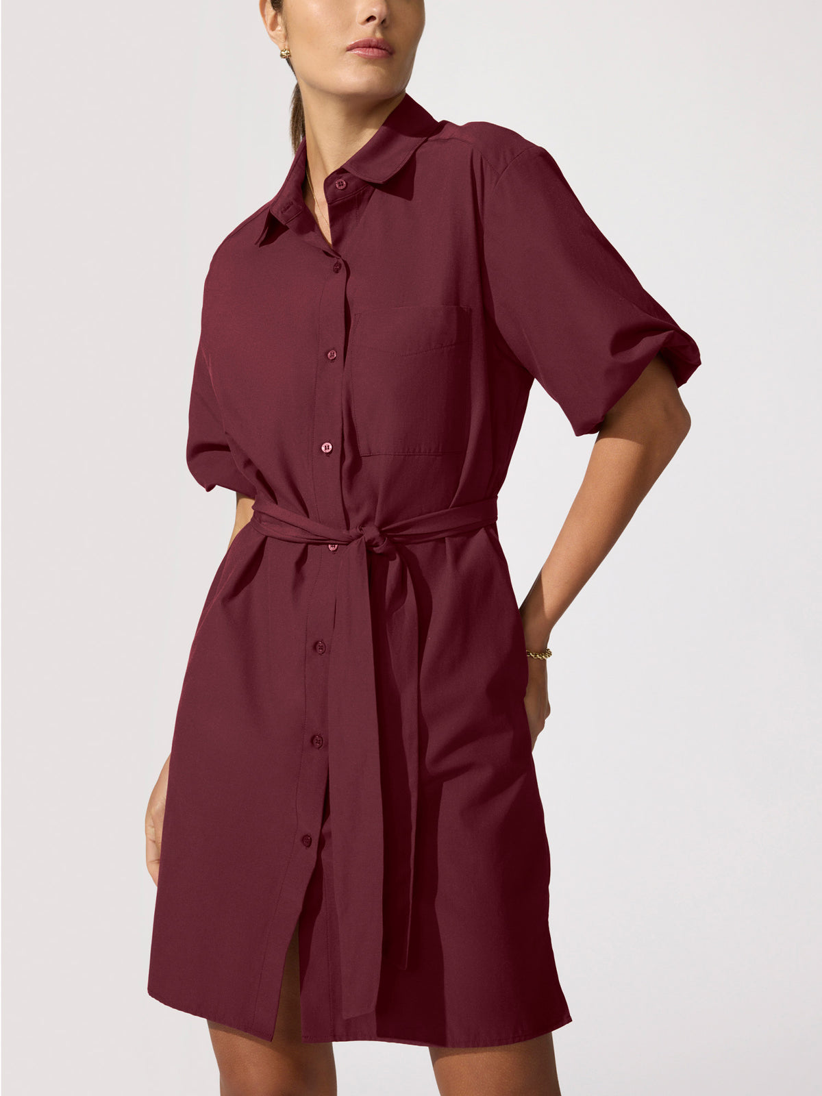 Studio shot of the Villa Dress in Umbria, a burgundy silk shirtdress with a tie waist, three-quarter view