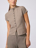 Woman wearing the Emmy cotton-wool cardigan in otter melange, a short-sleeve knit button-front top styled with matching knit trousers.