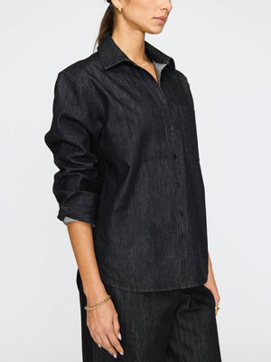 Women's denim shirt with front pocket detail, long sleeves, and a structured collar in a dark indigo wash.