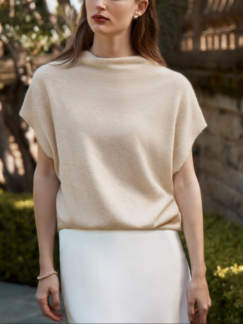 Women's cashmere top in soft cream with a draped funnel neck and sleeveless silhouette.