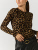 Women's leopard print crewneck sweater tucked into black leather pants with a black belt and oval gold buckle