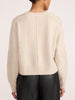 Back view of a women's cream cashmere crewneck sweater styled with black leather pants