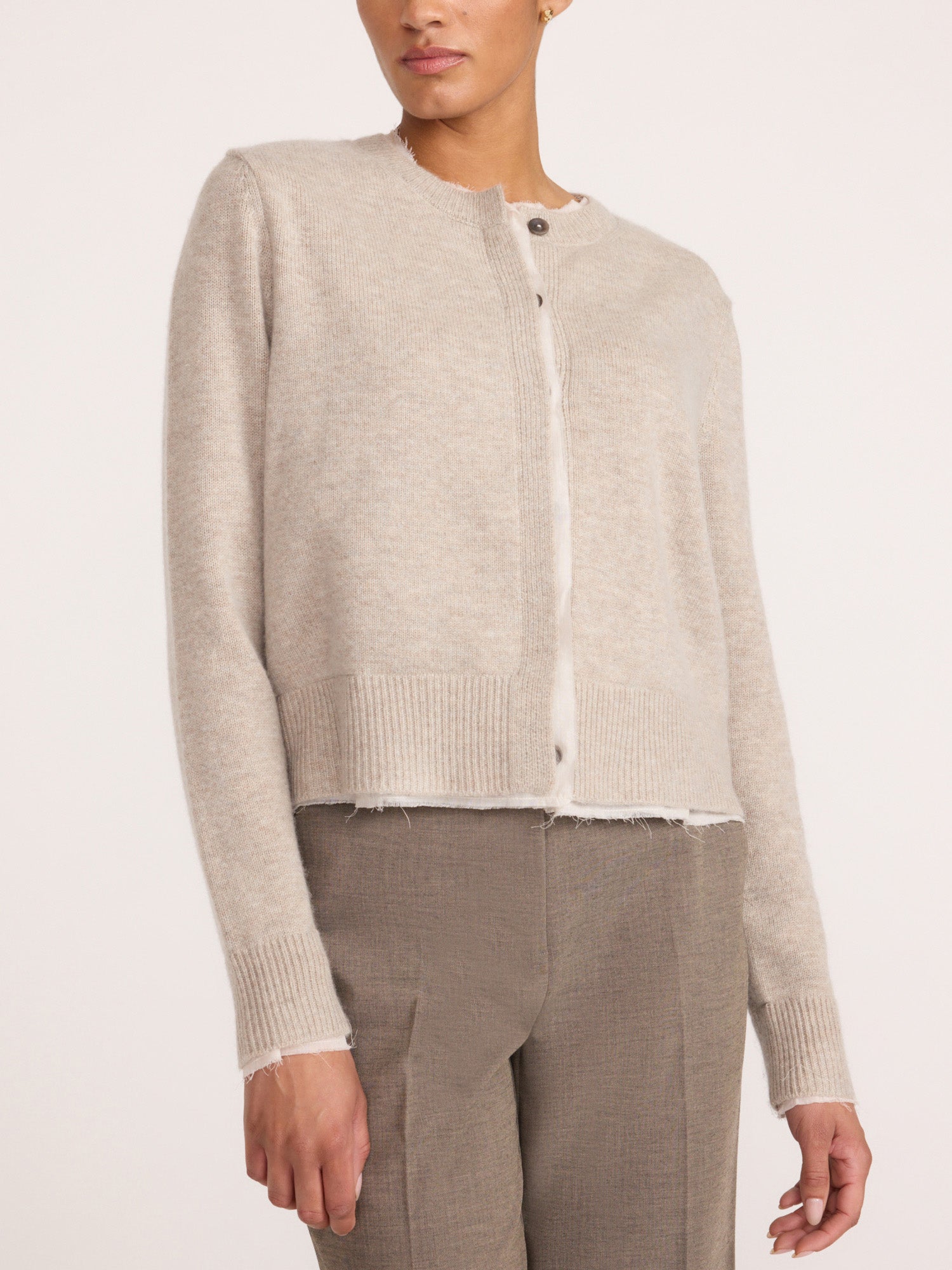Front view of a woman wearing the Brochu Walker Archie Layered Cardigan in Gravel Stone Melange, a cropped button-front knit cardigan with a raw hem.