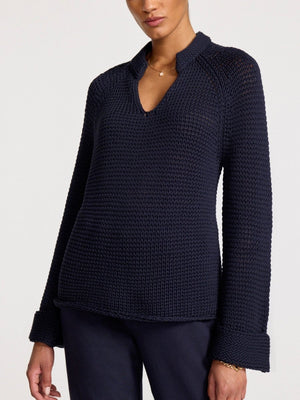Women's long sleeve navy sweater in a thick knit with a split neckline, raglan sleeves, and turned-up cuffs for a structured, cozy look.