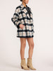 Side view of a woman wearing the Brochu Walker Bodhi Double Breasted Plaid Coat in Montclair Plaid, a double-breasted wool coat styled with beige ankle boots.