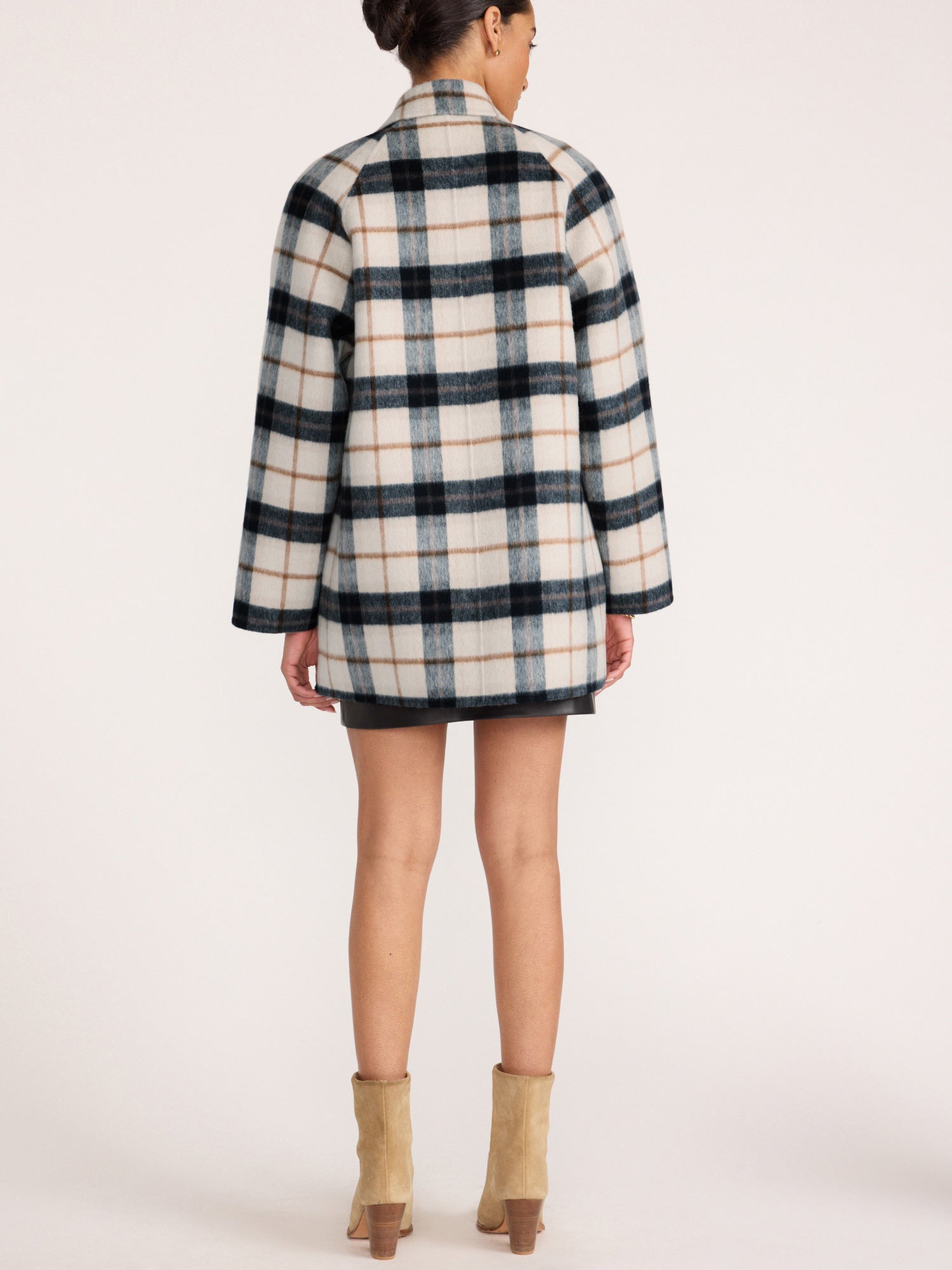 Back view of a woman wearing the Brochu Walker Bodhi Double Breasted Plaid Coat in Montclair Plaid, a wool plaid coat styled with beige ankle boots.