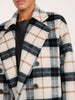 Close-up of the collar on the Brochu Walker Bodhi Double Breasted Plaid Coat in Montclair Plaid, a wool coat in cream, navy, and tan plaid.