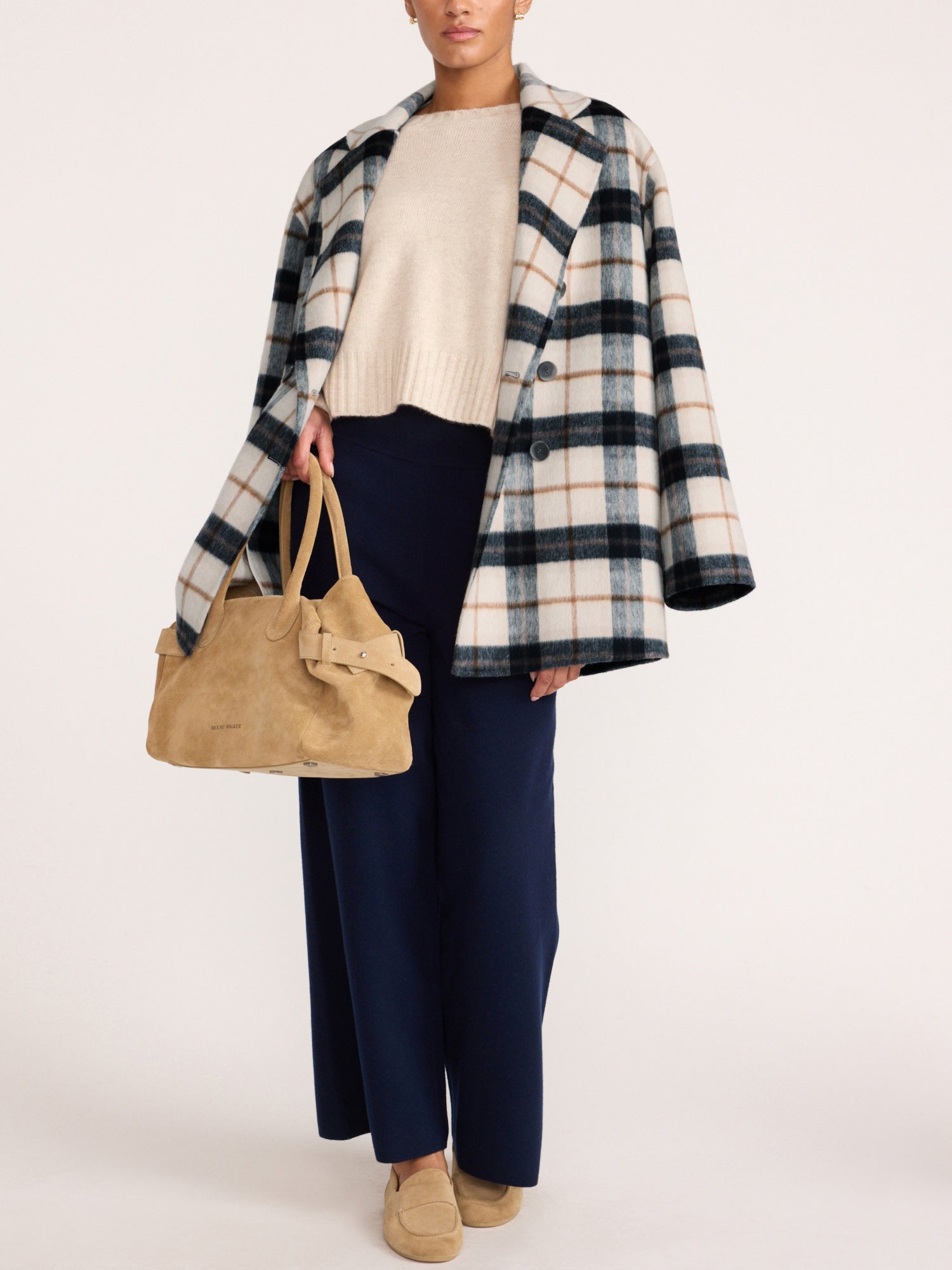 Woman wearing the Brochu Walker Bodhi Double Breasted Plaid Coat in Montclair Plaid, an oversized wool plaid coat over a cream sweater and navy wide-leg trousers.
