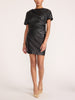 Full-length view of a woman wearing the Brochu Walker Cleo Top in Black Onyx, a faux-leather top and matching skirt, styled with beige high heels.