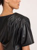 Close-up of the gathered shoulder detail on the Brochu Walker Cleo Top in Black Onyx, a faux-leather short-sleeve top.