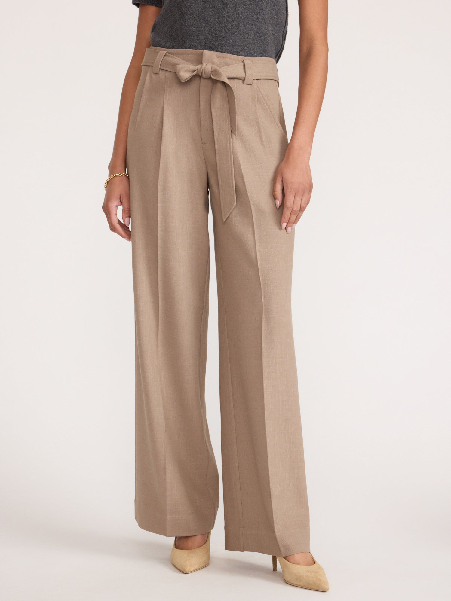 Three-quarter view of a woman wearing the Brochu Walker Duke Suit Pant in Tawny, high-waisted wide-leg trousers with a tied fabric belt at the waist.