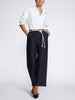 Front view of navy wide-leg pinstripe trousers with a tie-front waist, styled with a relaxed white shirt