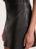 Close-up side view of the Brochu Walker Esme Miniskirt in Black Onyx, a faux-leather mini skirt showing the seam detail.