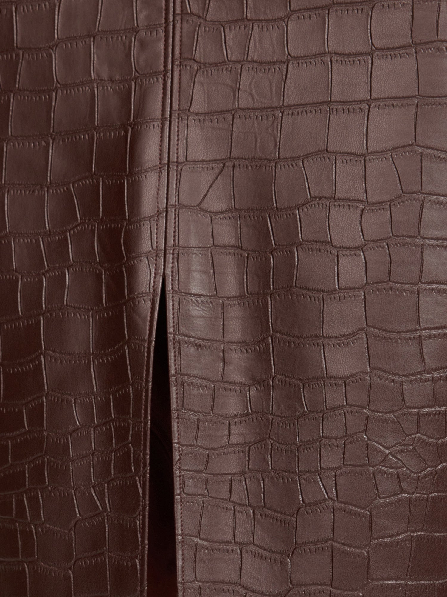 Vegan croco-embossed skirt in carob, close-up fabric detail with front slit