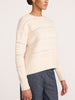 Side profile of a woman wearing the Brochu Walker Everyday Multistitch Bright Crew sweater in Oatmeal Melange, a textured open-knit crewneck sweater with blue jeans.