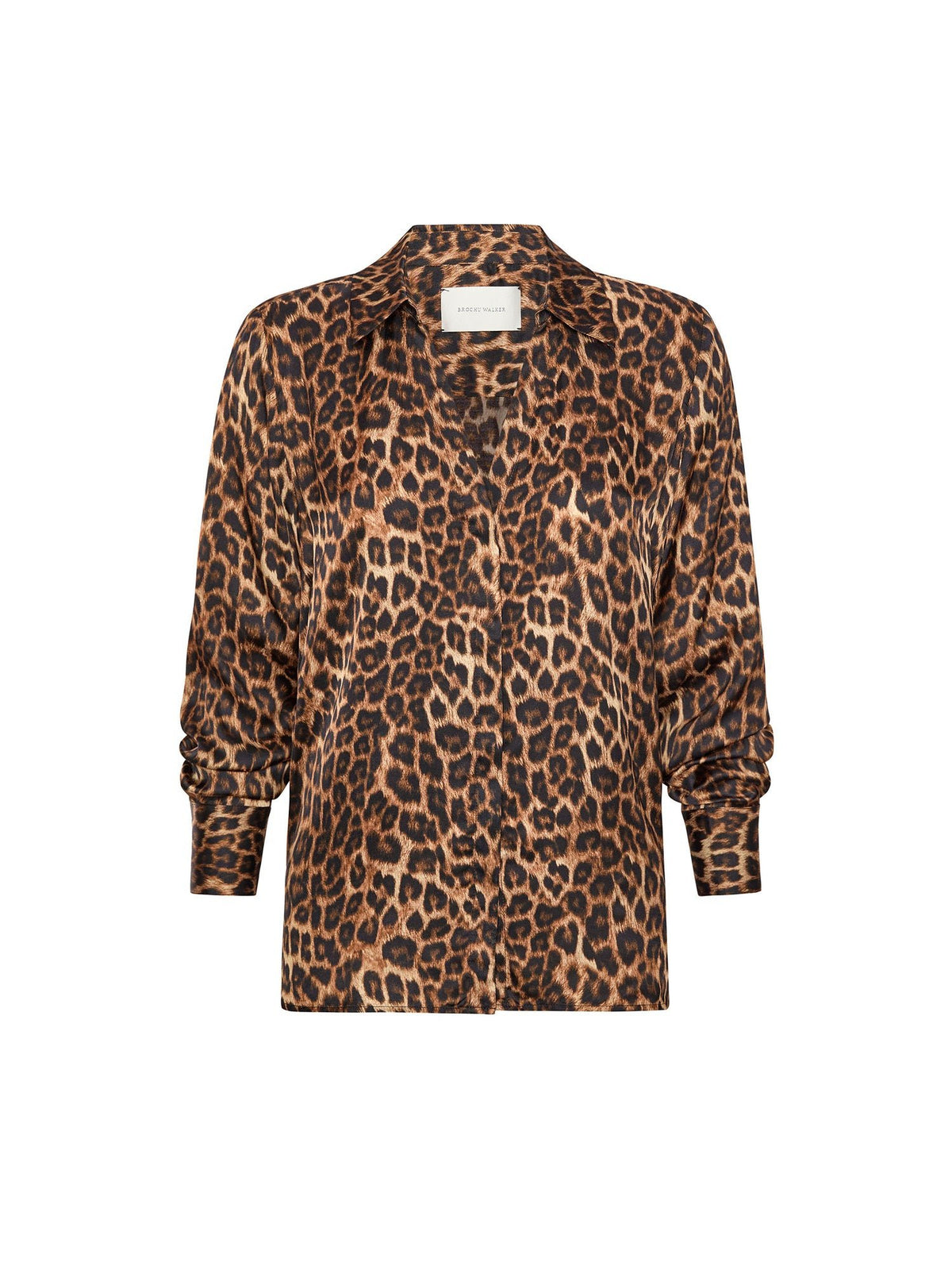 Woman wearing a leopard print satin button up blouse with a black croc embossed leather skirt, one hand in her pocket