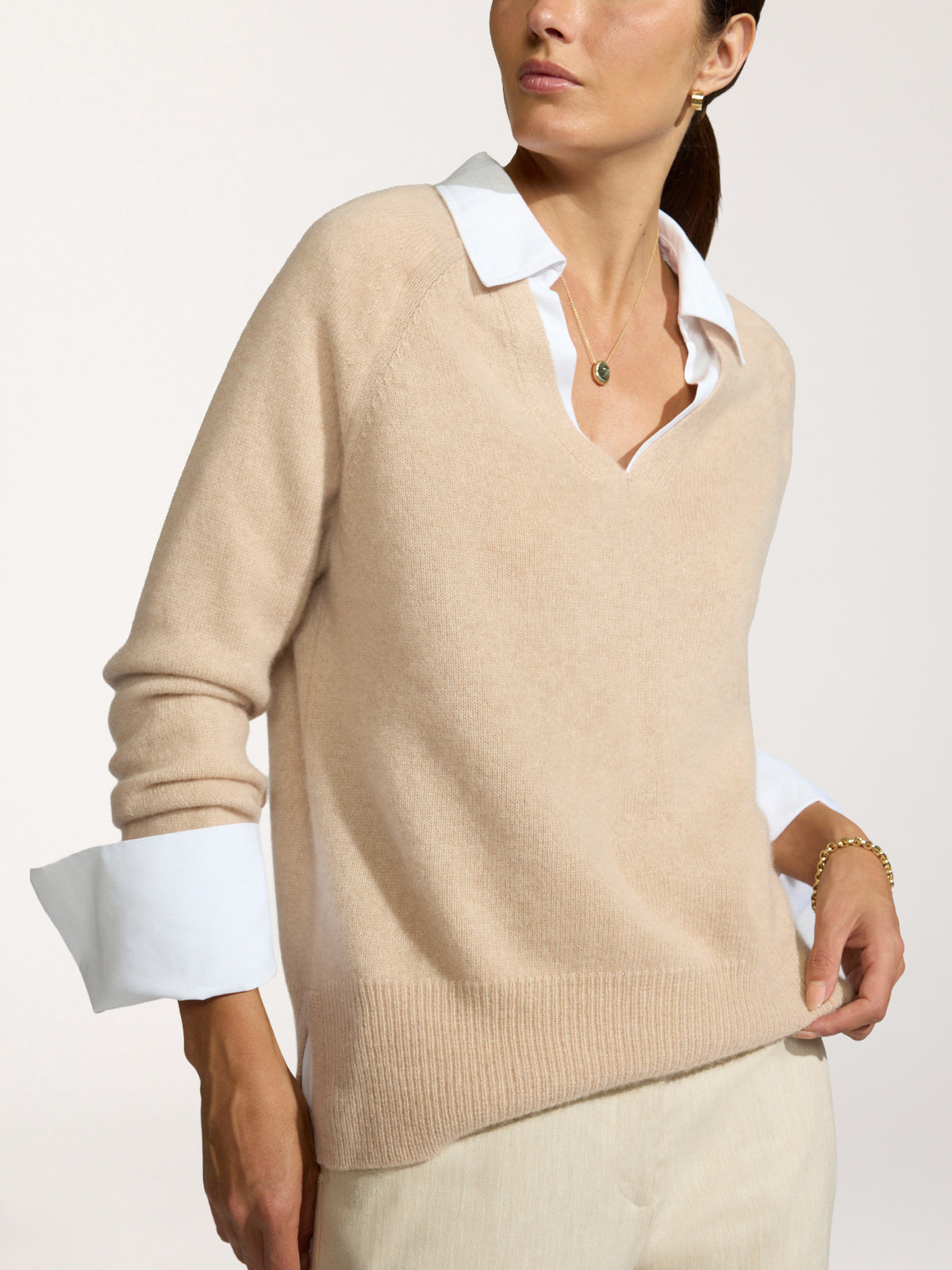 Model wearing the Ella layered pullover in camel over a white collared shirt with cream trousers