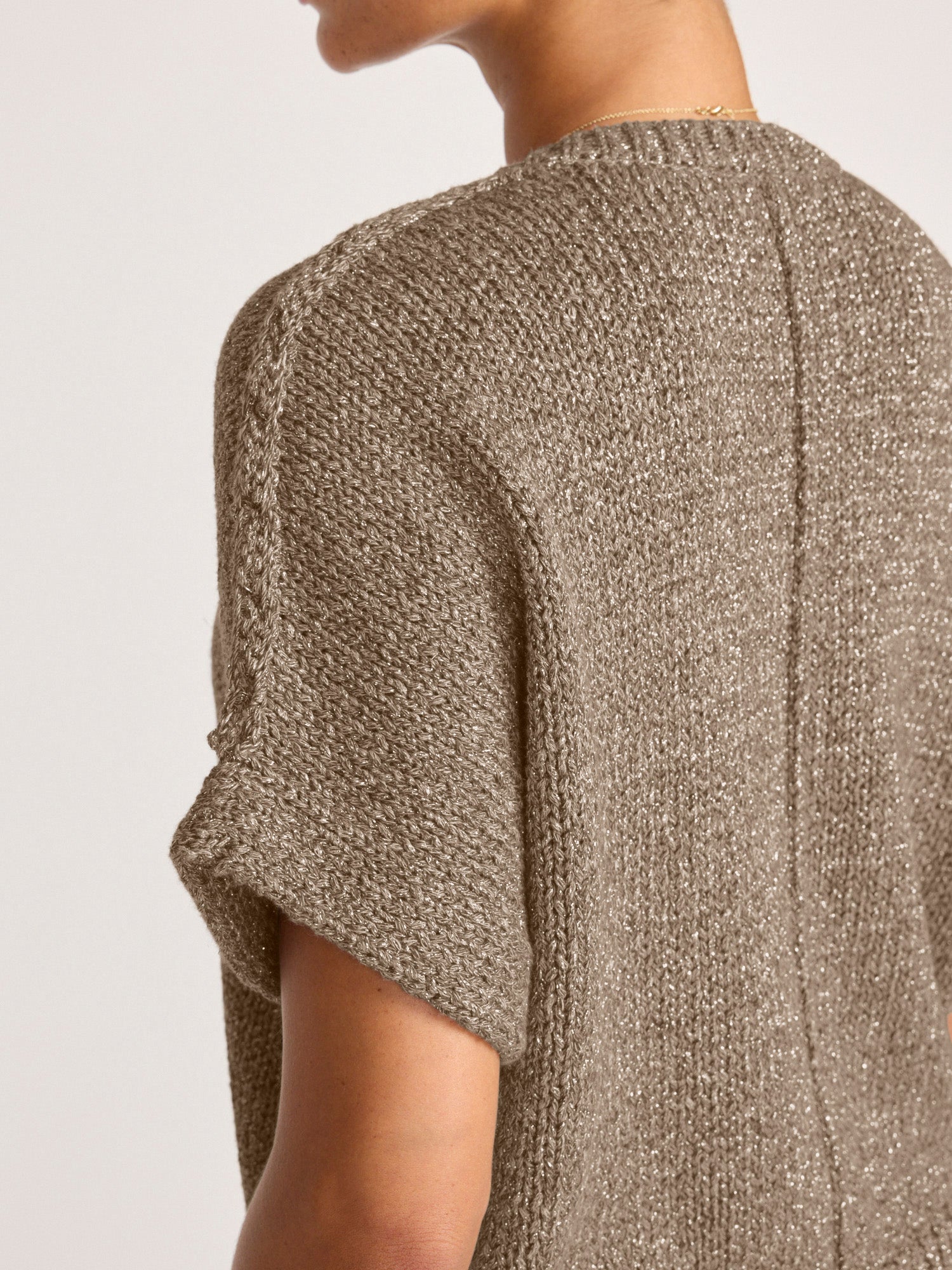 Side detail of the Gaia Metallic Tee in bronze, a short sleeve designer sweater with a shimmering knit texture.