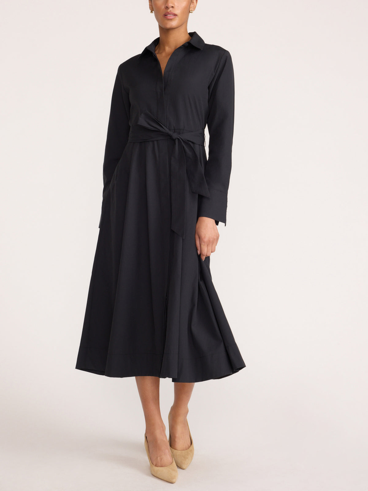Front view of a women's black midi shirt dress with a tie waist and heels