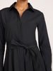 Close-up of a women's black collared shirt dress with a fabric tie belt at the waist