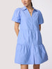 Close-up of a periwinkle blue mini shirtdress with puff sleeves, button-front placket, and tiered ruffle skirt on a model.